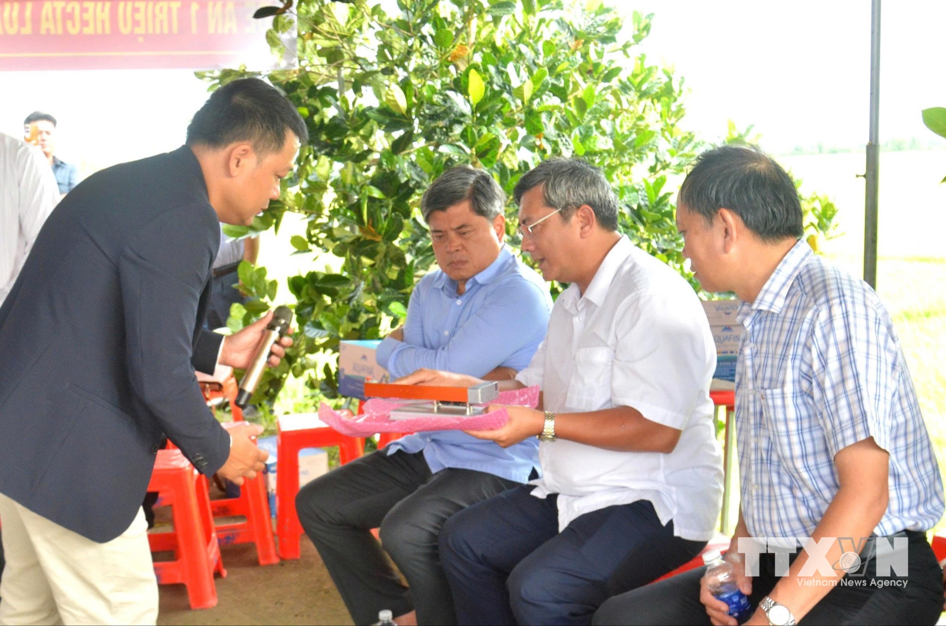 Đại diện công ty TNHH LUAGPT giới thiệu hệ thống thiết bị AWD thông minh giúp tiết kiệm nước, giảm phát thải khí nhà kính với Thứ trưởng Bộ NN&MT Trần Thanh Nam. (Ảnh: Văn Sĩ/TTXVN)